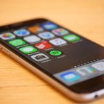 Smartphone exibindo vários ícones de aplicativos na tela.