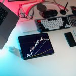 Mesa de escritório com dispositivos digitais exibindo análises financeiras.